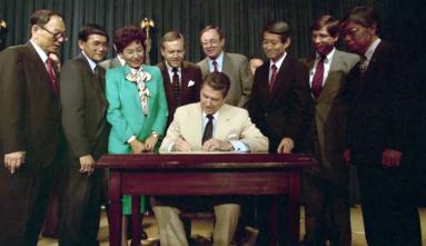 President Ronald Regan signs the civil liberties act 1988